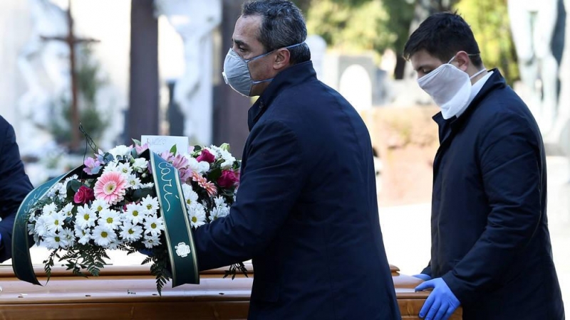 Trabajadores de la funeraria transportan el ataud de una persona muerta por coronavirus en Bérgamo (Italia) (Reuters)