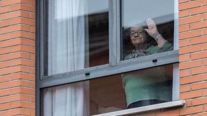Una mujer saluda desde una residencia de mayores. EFE