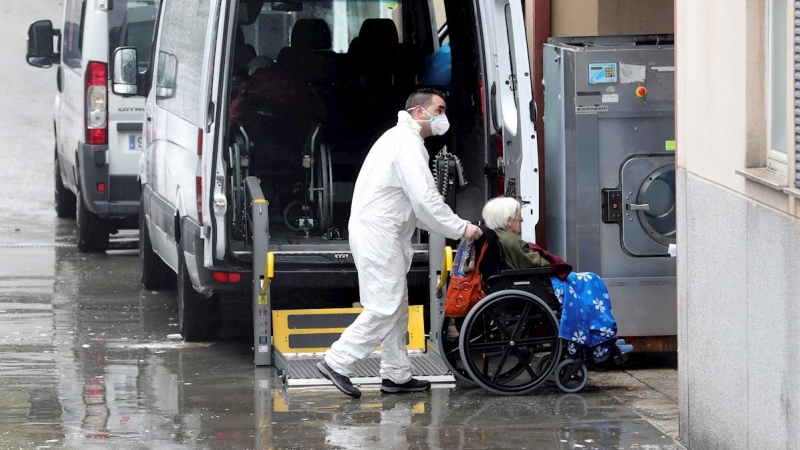 01/04/2020.- Trabajadores de la residencia Vitalia en Leganés, una de las varias residencias privadas de personas mayores que serán dirigidas por funcionarios, trasladan a una anciana no contagiada por coronavirus, este miércoles. La Consejería de Polític