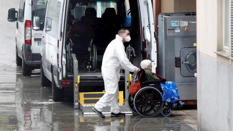 01/04/2020.- Trabajadores de la residencia Vitalia en Leganés, una de las varias residencias privadas de personas mayores que serán dirigidas por funcionarios, trasladan a una anciana no contagiada por coronavirus, este miércoles. La Consejería de Polític