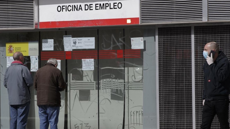 Dos ancianos leen los carteles de una oficina de empleo cerrada durante el primer día laborable desde que se decretó el estado de alarma, en Alcorcón (Madrid). E.P./Eduardo Parra