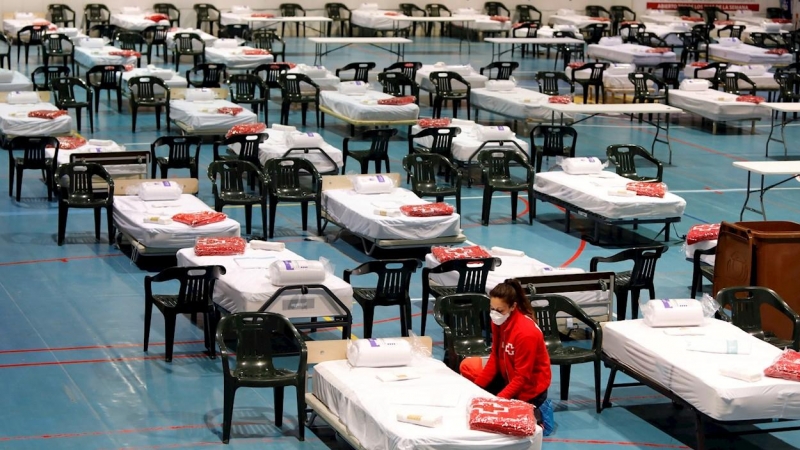 Miembros de la Cruz Roja instalando esta semana material en el pabellón de Les Comas de Igualada (Barcelona) donde se está preparando un hospital de campaña. EFE/Susanna Sáez