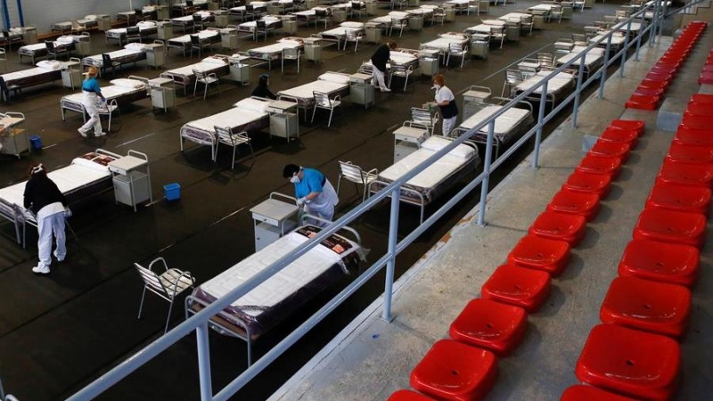 Empleadas municipales de Sant Andreu de la Barca limpian el hospital de campaña en un polideportivo de la localidad al que se derivarán personas contagiadas por coronavirus que reciban el alta hospitalaria pero que no pueden estar en casa. EFE / Quique Ga