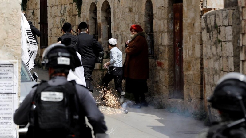 La Policía israelí lanza una granada aturdidora a varios judíos ultraortodoxos en las calles de Jerusalén./ Ronen Zvulun (Reuters)