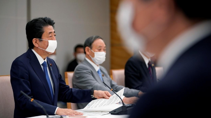 El primer ministro de Japón, Shinzo Abe, con mascarilla, con otros miembros de su gabinete para analizar las medidas frente a la pandemia del coronavirus. REUTERS/Franck Robichon