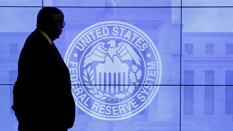 Un vigilante de seguridad, junto a un 'videowall' con el logo de la Reserva Federal. REUTERS/Kevin Lamarque