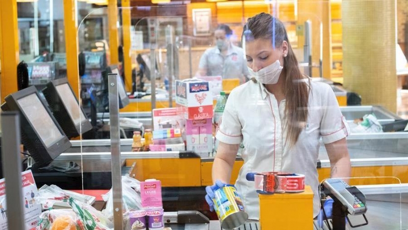 Una trabajadora de un supermercado atendiendo una compra. EFE