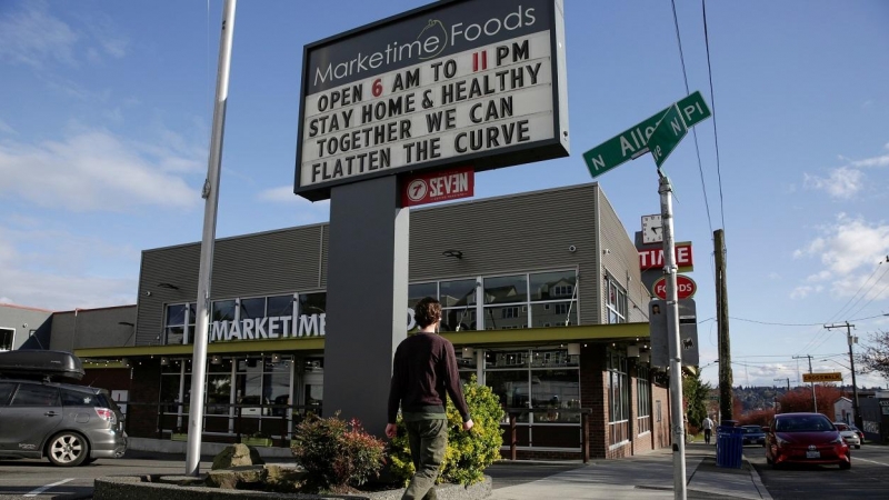 El letrero de un centro comercial pide 'quédese en casa y cuidese; juntos podemos aplanar la curva', en la ciudad de Seattle (Washington, EEUU). REUTERS / Jason Redmond