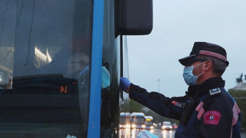 Un policía municipal entrega mascarillas a un conductor de autobús durante el confinamiento en por el coronavirus en Madrid. REUTERS / Susana Vera