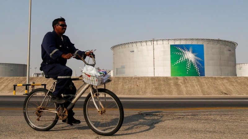 Un trabajador pasa, en bicicleta, cerca de uno de los tanques de almacenamiento de crudo de la petrolera estatal saudí Aramco, en sus instalaciones en  Abqaiq. REUTERS/Maxim Shemetov