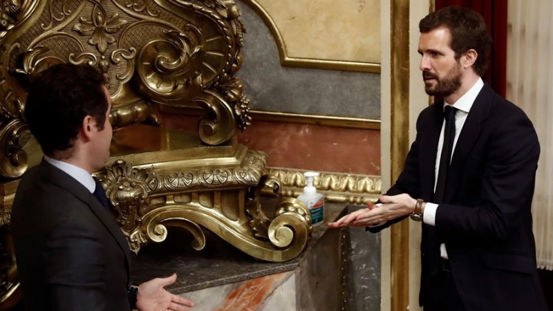 El líder del PP, Pablo Casado (d), y el secretario general del PP, Teodoro García Egea, desinfectan sus manos durante un pleno en el Congreso. - EFE