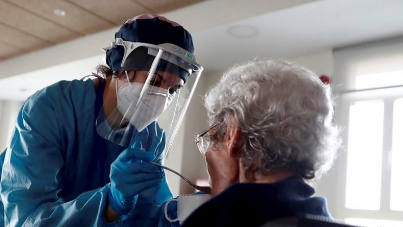 Una cuidadora ayuda a comer a una anciana en una residencia madrileña. EFE/Mariscal