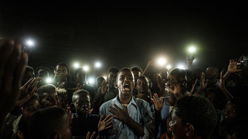 El fotógrafo japonés Yasuyoshi Chiba ha sido galardonado este jueves con el World Press Photo por su fotografía del grito pacífico de un grupo de jóvenes en Sudán, que iluminaban con sus teléfonos móviles a un chico mientras recitaba un poema. EFE/YASUYOS