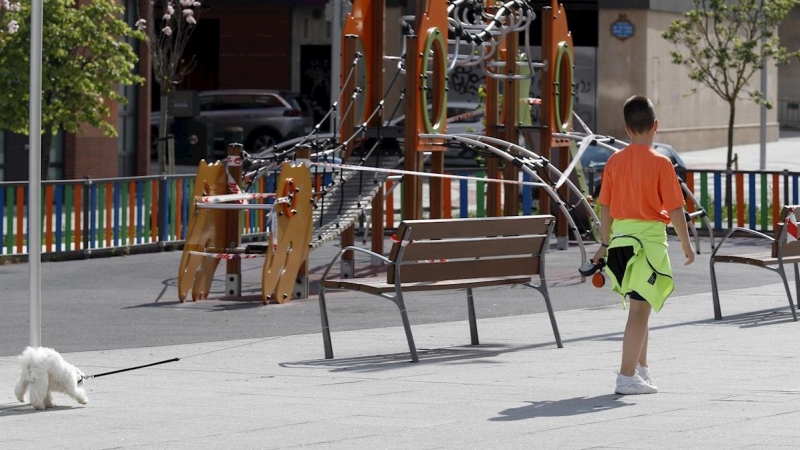 20/04/2020.-Un niño pasea el perro junto a un parque cerca de su casa este lunes en la capital vizcaína. EFE/LUIS TEJIDO