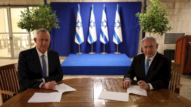 20/04/2020.- El primer ministro israelí, Benjamín Netanyahu (d), firma junto al centrista Beny Gantz (i) el acuerdo alcanzado este lunes mediante el cual Netanyahu seguirá siendo jefe de Gobierno israelí durante el primer año y medio de Ejecutivo unitario