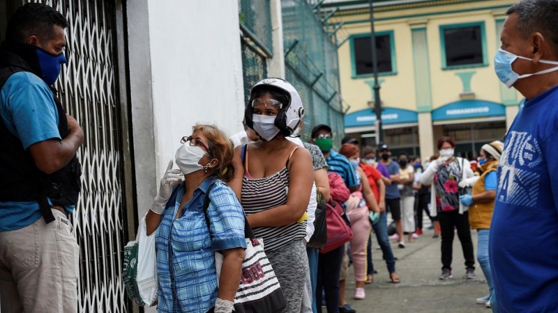 Varias personas hacen cola frente a una farmacia en Guayaquil, Ecuador. REUTERS