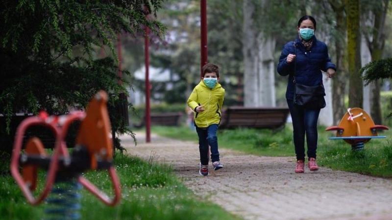 Un niño protegido con una mascarilla corre esta mañana por un parque de la ciudad de Valladolid durante el primer día en el que los menores de 14 años salen a la calle, acompañados de un adulto y durante una hora, después de más de cuarenta días de confin