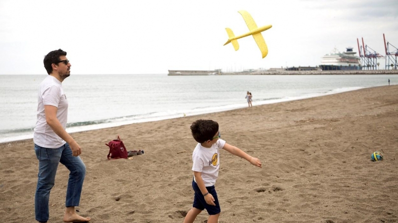 26/04/2020.- Un niño junto a su padre en la Playa de la Malagueta este domingo, cuadragésimo tercer día de estado de alarma, cuando más de seis millones de niños de hasta 14 años han podido salir por primera vez a la calle desde el inicio del confinamient