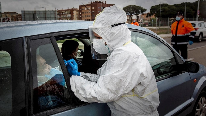 ARANDA DE DUERO (BURGOS), 27/04/2020.- Un sanitario realiza un test del coronavirus a una persona sin necesidad de que se baje del coche este lunes en Aranda de Duero (Burgos). EFE/ Paco Santamaria