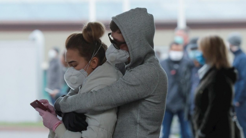 Imagen de archivo de dos personas durante la pandemia. EFE/EPA/Sergey Dolzhenko