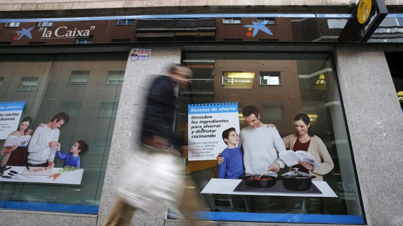 Un hombre pasa por delante de una oficina de Caixabank, en Madrid. EFE/Juan Carlos Hidalgo