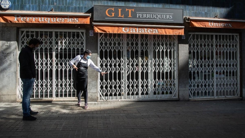 Una mujer señala en la calle Rosselló de Barcelona dónde dormía una persona sin techo asesinada el pasado lunes./ David Zorrakino (Europa Press)