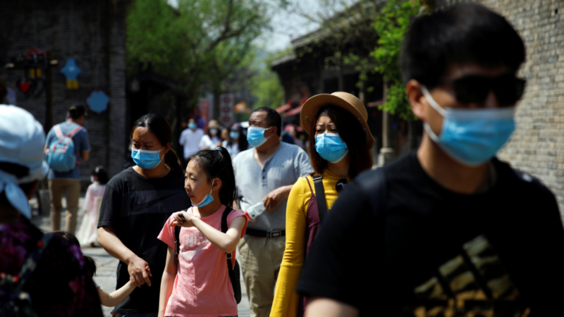 Personas con mascarilla en Beijing. REUTERS / Carlos Garcia Rawlins
