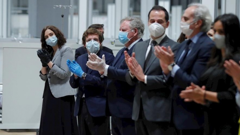 El alcade de Madrid, José Luis Martínez Almeida (2d), y la presidenta de la Comunidad de Madrid, Isabel Díaz Ayuso (i), entre otras autoridades, durante el acto de cierre en el interior del hospital de campaña del recinto ferial de Ifema este viernes, cua