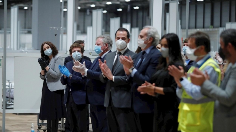 El alcade de Madrid, José Luis Martínez Almeida (2d), y la presidenta de la Comunidad de Madrid, Isabel Díaz Ayuso (i), entre otras autoridades, durante el acto de cierre en el interior del hospital de campaña del recinto ferial de Ifema este viernes, cua