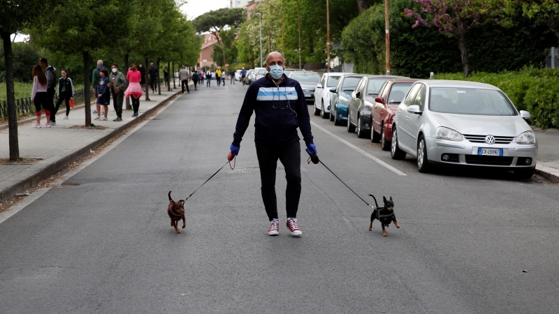 Un hombre pasea a sus perros en Roma. REUTERS/Remo Casilli