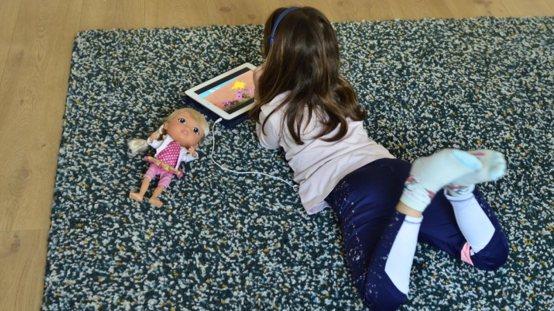 Niña juega con tableta en el confinamiento