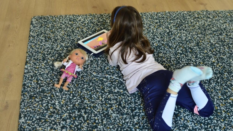 Niña juega con tableta en el confinamiento