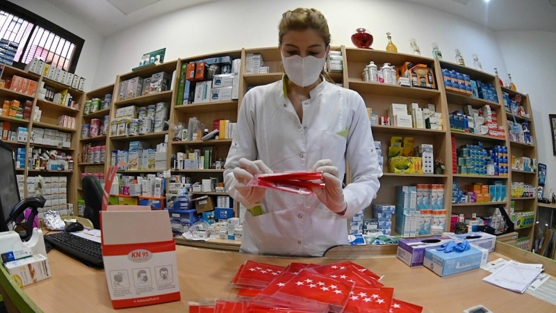 11/05/2020.- La trabajadora prepara las mascarillas que se repartirán gratuitamente entre los ciudadanos, este lunes, en una farmacia de Alcalá de Henares, Madrid. Los madrileños podrán recoger desde este lunes y durante 15 días una mascarilla FFP2 de for