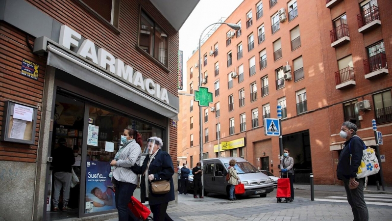 Varias personas hacen cola manteniendo la distancia de seguridad en una farmacia de Madrid. / EFE - DAVID FERNÁNDEZ