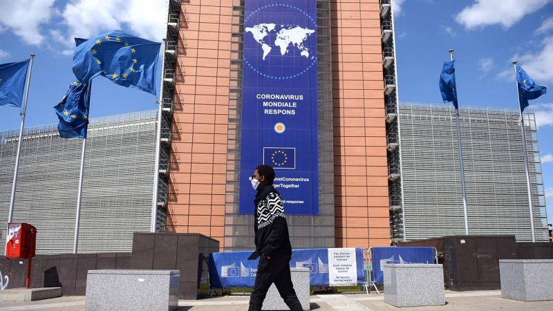 Un hombre con mascarilla pasa por delante de la sede de la Comisión Europea, en Bruselas. REUTERS/Johanna Geron