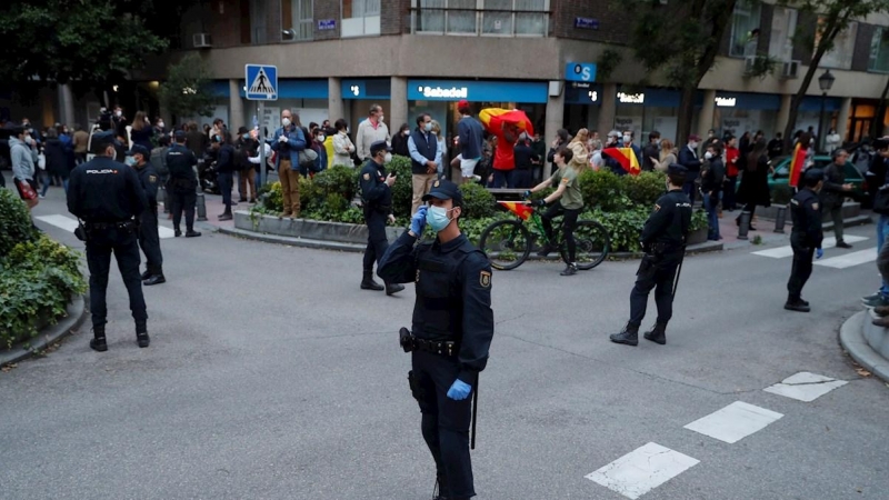Vecinos del madrileño barrio de Salamanca se manifiestan contra el Gobierno, vigilados por un fuerte dispositivo policial, por su gestión en la crisis del coronavirus, este jueves en Madrid. EFE