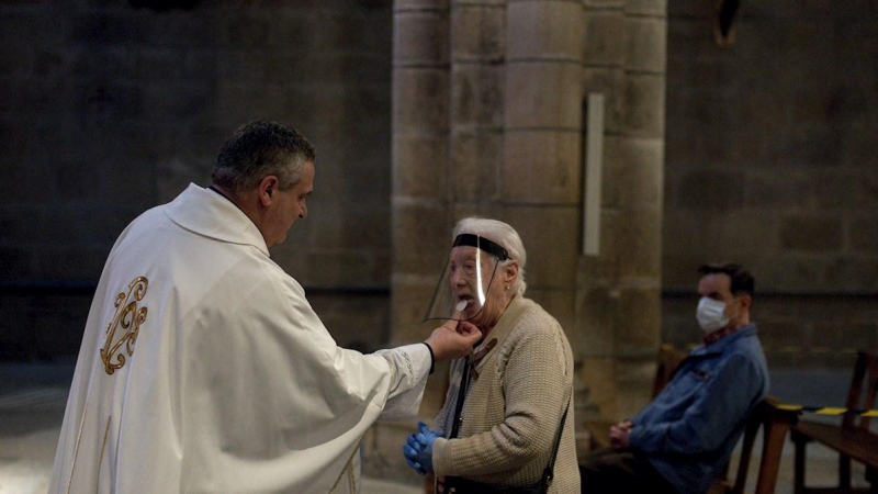 11/05/2020.- Una mujer comulga durante la celebración de misa en el interior de la catedral de Ourense. / EFE - BRAIS LORENZO