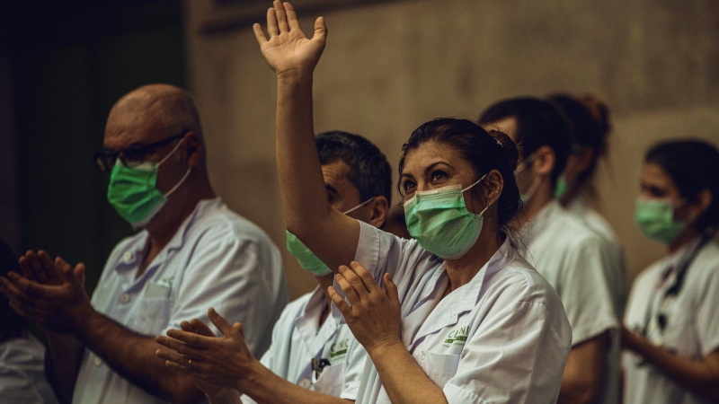 El personal sanitari de l’Hospital Clínic aplaudeix, després de la crida a través de les xarxes per a una darrera ronda d’aplaudiments en homenatge a professionals sanitaris i altres sectors, que lluiten contra la pandèmia del coronavirus.  Matthias Oeste
