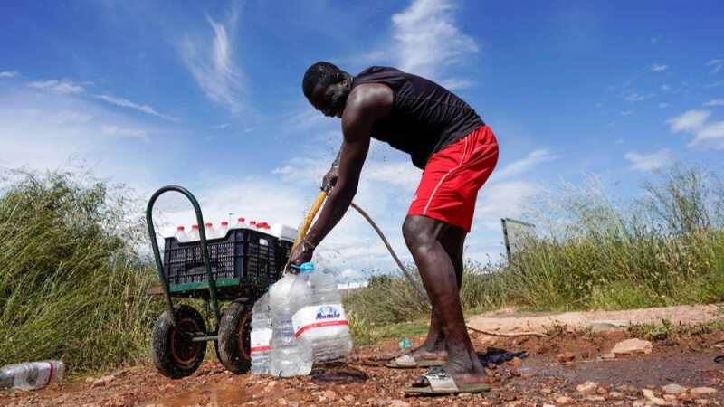 Un trabajador senegalés llena botellas de agua en deprimido del Nazareno, durante el brote de la covid 19 en Níjar, Almería. REUTERS / Juan Medina