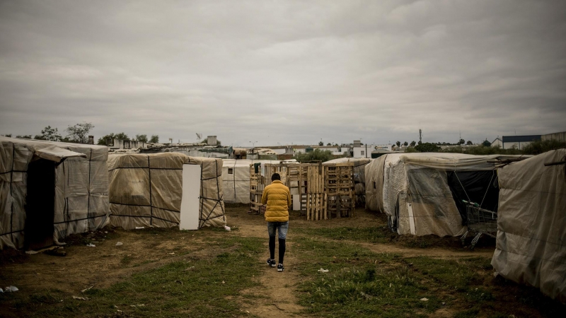 Un migrante subsahariano camina hacia la cabaña donde vive en Lepe, Huelva. Más de 1.400 migrantes viven en pésimas condiciones solo en la localidad, llegando a 3.000 en la provincia onubense.- JAVIER FERGO