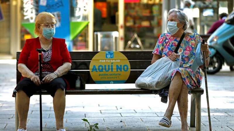 Dos mujeres conversan en un banco de L'Hospitalet (Barcelona) este jueves. EFE/Toni Albir