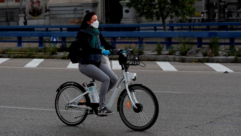 Una mujer con mascarilla y guantes usa una bicicleta del servicio BiciMAD, en Madrid. EFE/Chema Moya