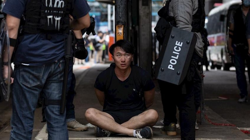 La policía detiene a un manifestante durante una manifestación contra la implementación de la ley de seguridad nacional en Hong Kong. EFE / JEROME FAVRE