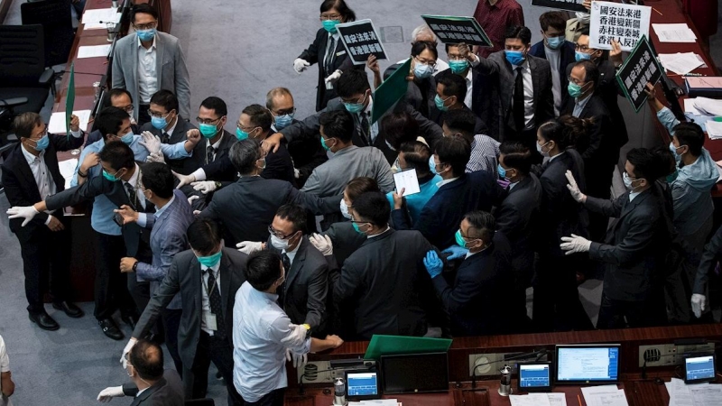 Los guardias de seguridad escoltan al legislador pro-Beijing y al presidente del Comité de la Cámara Starry Lee fuera de la cámara en el Consejo Legislativo en Hong Kong el 22 de mayo de 2020, trans anunciarse la nueva ley de seguridad nacional. EFE / JER