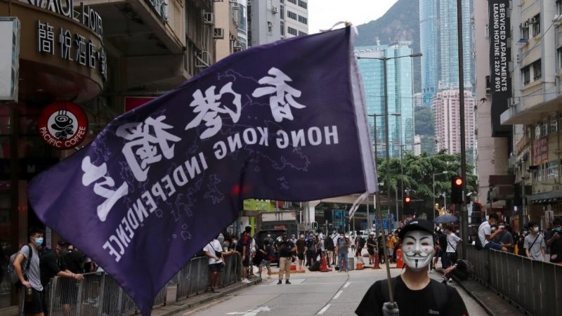 Un manifestante antigubernamental enmascarado sostiene una bandera que apoya la independencia de Hong Kong durante una marcha contra los planes de Beijing de imponer una legislación de seguridad nacional. REUTERS / Tyrone Siu