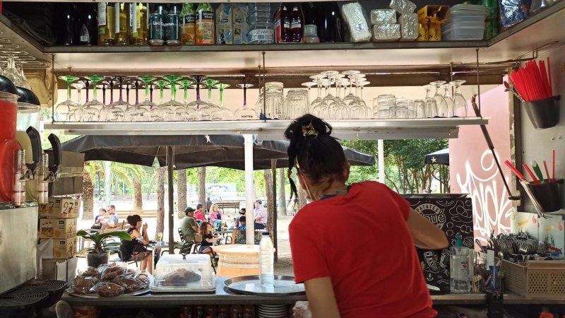 La cambrera del bar-xiringuito Tsunami dels Jardins del Baix Guinardó treballa durant el primer dia amb les terrasses obertes. Maria Rubio