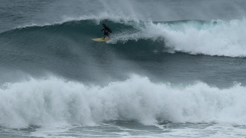 Sydney (Australia), 25/05 / 2020.- Se ve a un surfista montando una ola durante grandes olas en Collaroy Beach en Sydney, Australia, el 25 de mayo de 2020. Según informes de los medios, se registraron olas de hasta cinco metros en la costa de Sydney duran