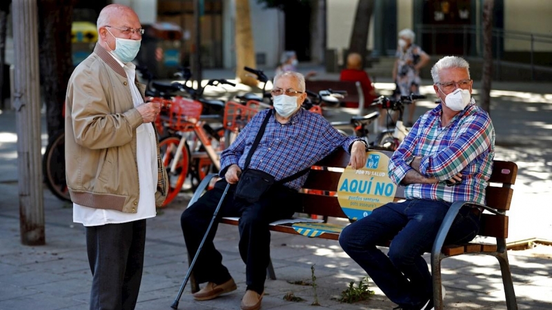 Tres hombres conversan en una plaza de Barcelona. EFE