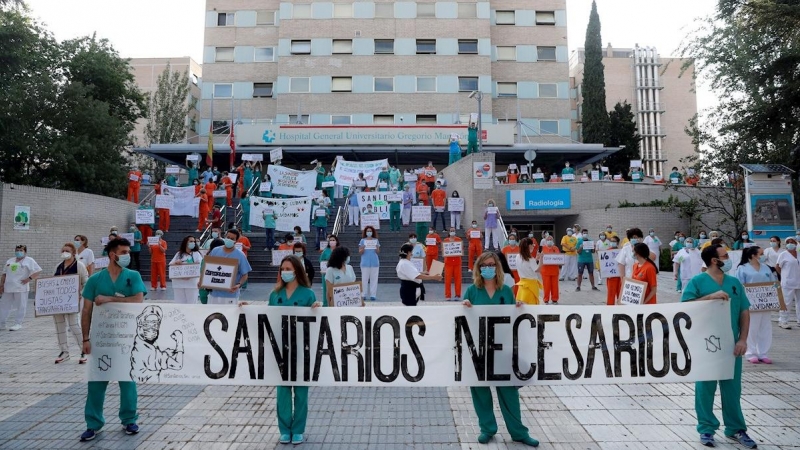 GRAF1941. MADRID, 25/05/2020.- Miembros del personal sanitario del Hospital Gregorio Marañón posan con una pancarta en la que se lee 'Sanitarios necesarios' durante una concentración este lunes en el exterior del hospital en Madrid, en la primera jornada