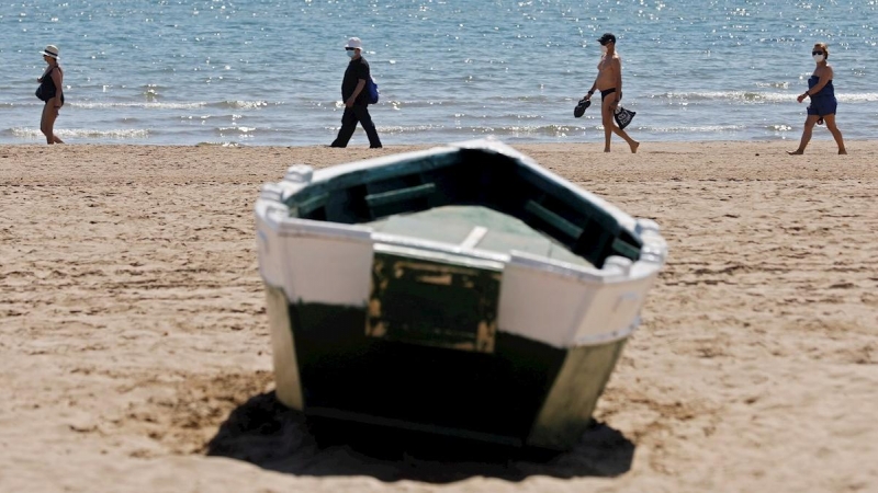 Cuatro personas disfrutan del buen tiempo y del calor en la playa de la Malvarrosa, el pasado viernes. EFE/Kai Försterling